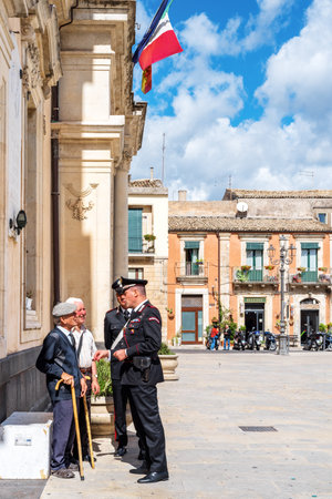 Syracuse Sicily / Italy - october 04 2019: Carabinieri discussed with two elderly people in the town squareのeditorial素材