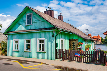 Old Lithuanian traditional wooden house with three windows and medieval castleのeditorial素材