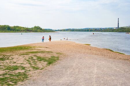 Confluence of two rivers, Namunas and Neris, in Kaunas old town, Lithuania, with two girls walking on the beachの写真素材