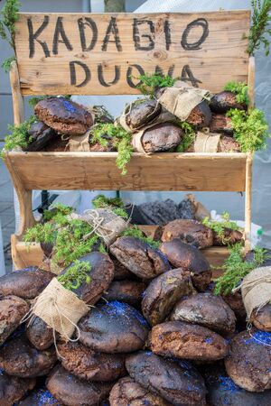 Homemade black cereal and juniper bread with hemp seeds in a street food traditional market, veticalの写真素材