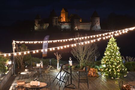 Medieval castle of Trakai, Vilnius, Lithuania, Eastern Europe, located between beautiful lakes and nature with wooden bridge and lights, at night, view from restaurant decorated for Christmasのeditorial素材