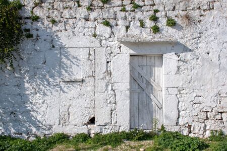 Ancient old white stone house in a countryside village in Puglia, Italy, Europe with plant capersのeditorial素材