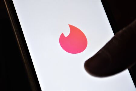 Close up view of Tinder, location-based social search mobile app and Web application most often used as a dating service with fingerのeditorial素材