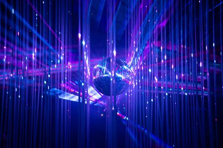 Dance floor disco night with a mirror ball symbol of fun and party in a nightclub or dance club with glowing stage lights and reflections, blue, violet, purpleの写真素材