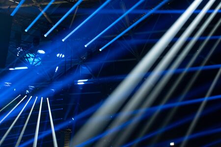 Scene, stage lights with colored spotlights and smoke, beams of lights background, white and blueの写真素材