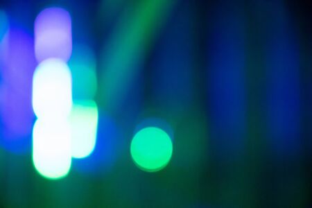 Abstract background with defocused bokeh colorful lights, glowing sparkling lights and reflectionsの写真素材