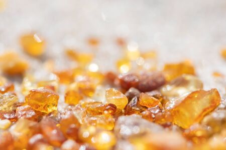 Beautiful pieces of amber on the sandy beach, amber background, close upの写真素材