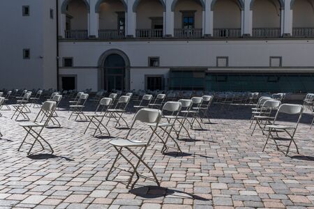 Social distancing during Covid or Coronavirus crisis, chairs keeping distance during a show, concert or exhibition, theater or cinemaの写真素材