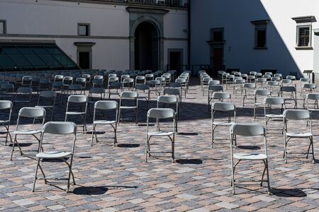 Social distancing during Covid or Coronavirus crisis, chairs keeping distance during a show, concert or exhibition, theater or cinemaの写真素材