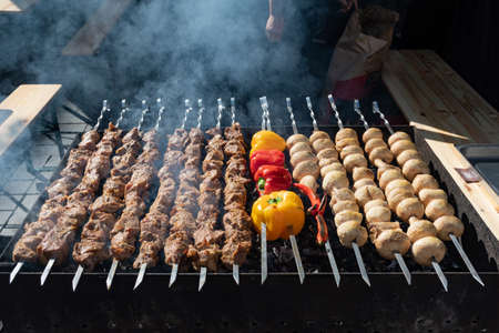 Close up of meat skewers, grilled in a barbecue, shashlik or shashlyk, with peppers, paprika and mushrooms, street market, festival, fairの写真素材