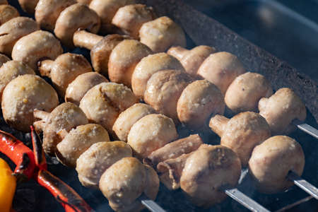 Close up of mushrooms skewers, grilled in a barbecue in a street market, festival, fairの写真素材