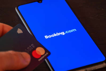 Booking.com logo displayed on the smartphone with credit card, travel and hotel industry crisis due to Covid or Coronavirus pandemic, data breachのeditorial素材