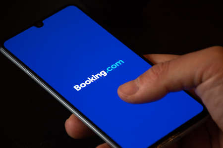 Booking.com logo displayed on the smartphone with finger, travel and hotel industry crisis due to Covid or Coronavirus pandemic, data breachのeditorial素材