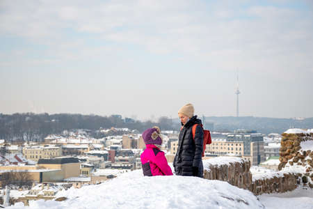Vilnius, Lithuania - February 17 2021: Aerial view of Vilnius old town, capital of Lithuania in winter day with roof covered by the snow and girl with kid or childのeditorial素材