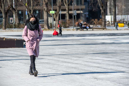 Vilnius, Lithuania - March 9 2021: Beautiful girl wearing mask walking in the city center during virus outbreakのeditorial素材