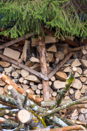 Stack or pile composed of blocks, pieces or logs of wood in winter or spring with snow. Stacking...