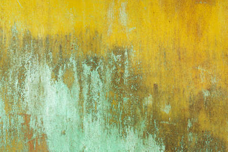 Wooden background of peeling cracked surface. Abstract pattern in rustic style, yellow, green, white colorの写真素材