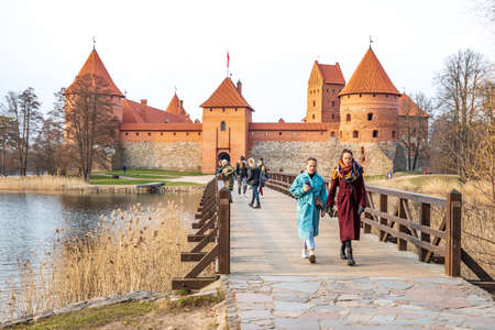 Trakai, Lithuania - April 10 2021: Medieval castle of Trakai, Vilnius, Lithuania, Eastern Europe, located between beautiful lakes and nature with people walking on the wooden bridgeのeditorial素材