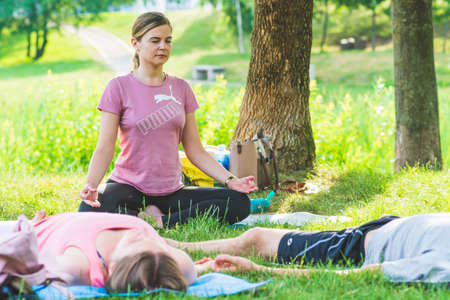 Vilnius, Lithuania - July 1 2021: Outdoor or outside yoga class or lesson on the grass in the park...