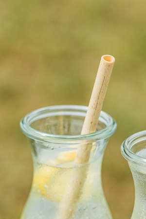 Fresh lemonade in a glass jugs with fully biodegradable and organic bamboo straw, verticalの写真素材