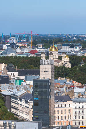 Riga, Latvia - September 19 2021:  Riga panorama with clock tower at the central station and Russian Orthodox Church, Nativity of Christ Cathedral, verticalのeditorial素材