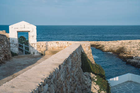Mediterranean sea landscape with rocky cliff, beautiful blue sea, vegetation, stone walls and masonry constructionsの写真素材