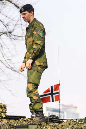 Vilnius, Lithuania - February 16 2022: Norwegian Army armored tank with cannon and camouflage coating with soldier on it and flag of Norway, verticalのeditorial素材