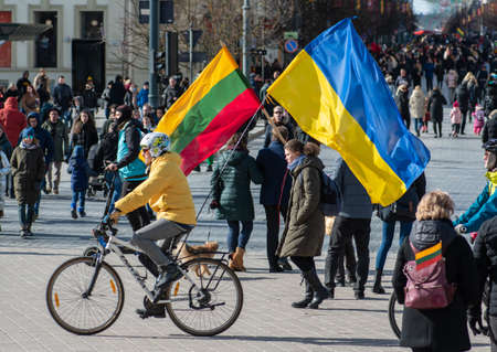 Vilnius, Lithuania - March 11, 2022: Peaceful demonstration against war, Putin and Russia in support of Ukraine with bikes, people with Ukrainian and Lithuanian flagsのeditorial素材