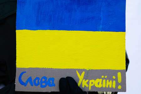 Beautiful painted Ukrainian flag during a peaceful demonstration against war, Putin and Russia in support of Ukraine, background, copy space. Glory to Ukraineのeditorial素材