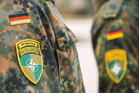 Berlin, Germany - March 29 2022: Flag of Germany and symbol of NATO battle group on soldiers uniform, NATO force integration unit, close upのeditorial素材