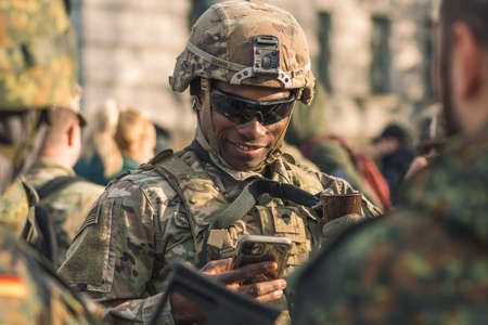 United States - March 29 2022: Smiling United States Marine Corps soldier with sunglasses, shotgun and armored vehicle humvee on background during war, USA or US army troopsのeditorial素材