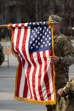 United States - March 29 2022: United States Marine Corps soldiers roll up American flag, USA or US...