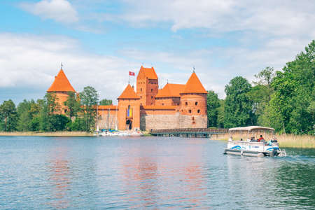 Trakai, Vilnius, Lithuania - June 3 2022: Medieval castle of Trakai, Vilnius, Lithuania, Eastern Europe, surrounded by beautiful lakes and nature in summer with wooden bridge, boatのeditorial素材