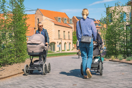 Odense, Denmark - May 23 2022: Beautiful young blonde hair girls with stroller walking on a new bike path or road between modern buildings in the center of Odense, Denmarkのeditorial素材