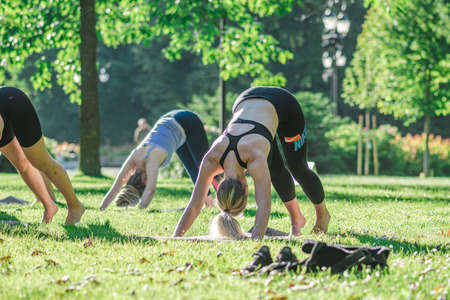 Vilnius, Lithuania - June 22 2022: Beautiful girls making outdoor or outside activity, yoga or gym on the grass in a public park in summerのeditorial素材