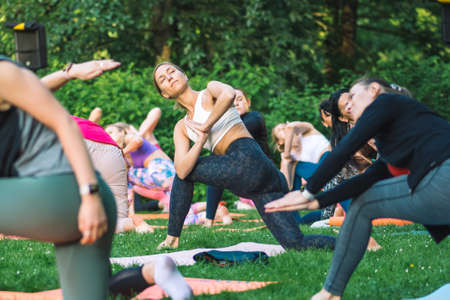 Vilnius, Lithuania - June 22 2022: Beautiful girls making outdoor or outside activity, yoga or gym on the grass in a public park in summerのeditorial素材