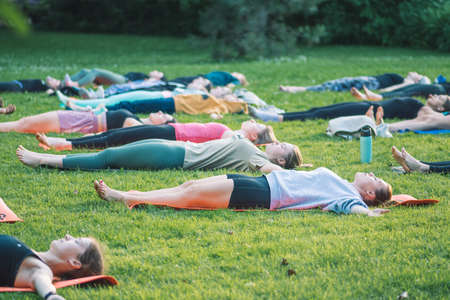 Vilnius, Lithuania - June 22 2022: Beautiful girls making outdoor or outside activity, yoga or gym on the grass in a public park in summerのeditorial素材