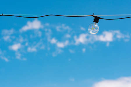 Vintage light bulbs with blue sky and white clouds on backgroud. Electricity concept. Earth hour. Energy consumption and environmental conservation, energy saving, Earth Hourの写真素材