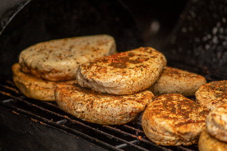 Smoking bio natural seasoned cheese with spices in a smoker in a street food market, close upの写真素材