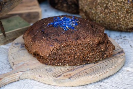 Homemade black rye cereal bread with hemp seeds in a traditional street food market, close upの写真素材