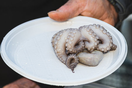 Fresh raw octopus ready to eat in a plate in a street fish market in Bari, Puglia, Italy