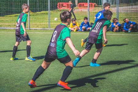 Turin, Italy - August 23 2023: Children or kids playing football or soccer during a match on an artificial grass soccer pitchのeditorial素材