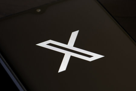 San Francisco, United States - August 30 2023: Twitter or X initial logo and app on a smartphone on black background. Online social media and social networking servicesのeditorial素材