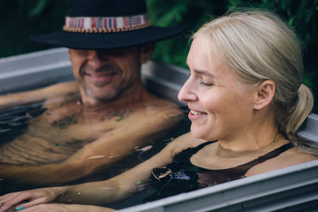 Vilnius, Lithuania - September 10 2023: Beautiful young caucasian couple ice bathing in the cold water among ice cubes. Wim Hof Method, cold therapy, breathing techniques, yoga andのeditorial素材