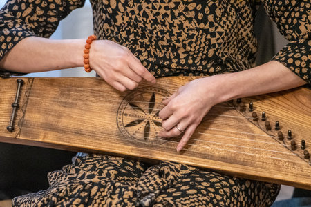 Fingers of a girl playing kankles, Lithuanian plucked string instrument belonging to the Baltic box zither family known as the Baltic psaltery, in Latvian kokles, Estonian kannelの写真素材