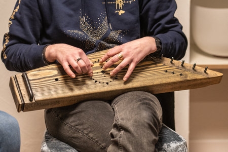 Fingers of a girl playing kankles, Lithuanian plucked string instrument belonging to the Baltic box zither family known as the Baltic psaltery, in Latvian kokles, Estonian kannelの写真素材