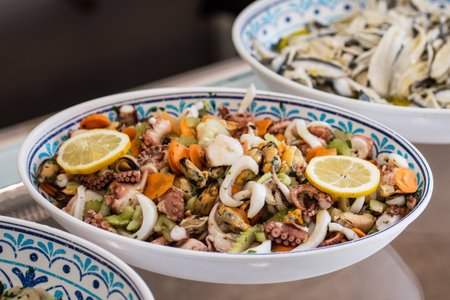 Insalata di Mare, Italian Seafood Salad in a ceramic plate. Italy's classic light, bright salad of gently cooked and marinated seafood with lemon juice, olive oil, parsley, and subの写真素材