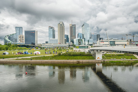 Vilnius, Lithuania - May 18 2025: View of the city from the white bridge, modern business financial district, modern architecture, buildings and skyscrapers with dramatic cloudy skの写真素材