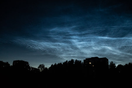 Noctilucent clouds or night-shining clouds on a summer night over the roofs of houses in Vilnius, Lithuania, Europeの写真素材