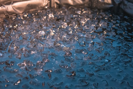 Portable plastic tub in a garden ready for ice bathing in the cold water filled with ice cubes. Wim...